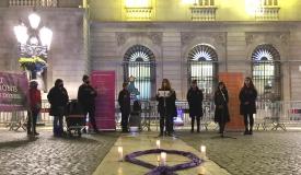 Imatge on es veu un llaç lila i les dones participants a la concentració 