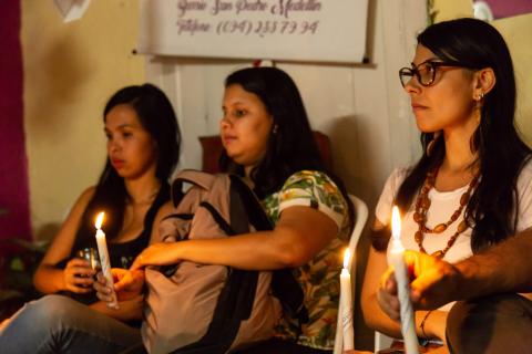 Dones amb espelmes a la mà en un acte públic