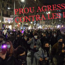 Imatge d'una manifestació i un escrit que diu "Prou agressions contra les dones!"